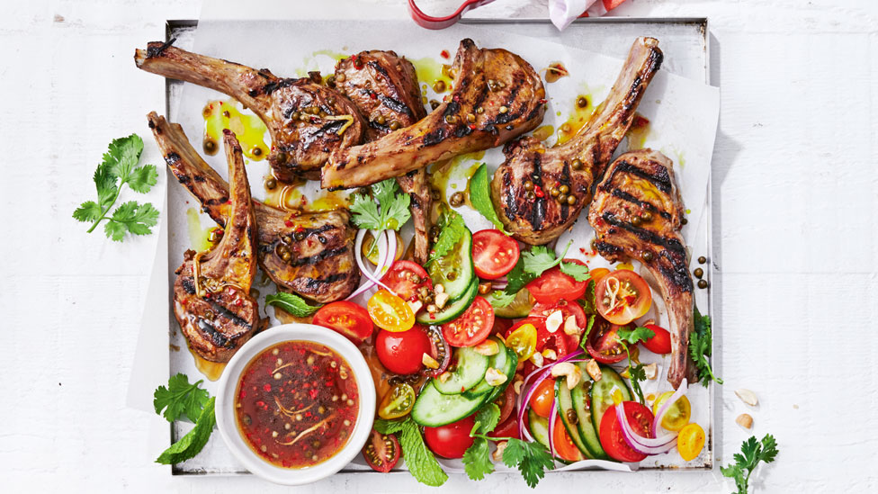 A table of lamb cutlets and salad with a thai dressing